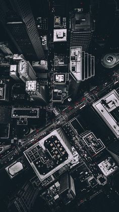 an aerial view of a city with lots of tall buildings and streets in black and white