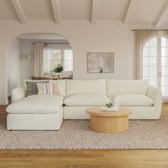 a large white couch sitting in a living room on top of a hard wood floor