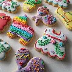 decorated cookies are arranged on a white surface