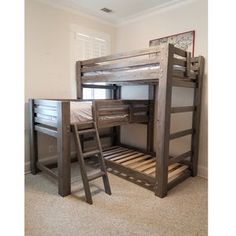 two bunk beds with ladders are in the middle of a room that has carpeted flooring