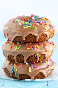 three cookies with chocolate frosting and sprinkles stacked on top of each other