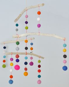 a colorful mobile is hanging from a tree branch with the word hello written on it