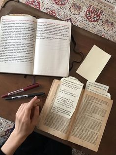 an open book on a table next to a pen and some papers with writing in them