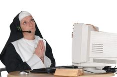 a nun sitting at a desk with a computer