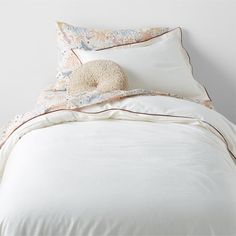 a bed with white sheets and pillows on it