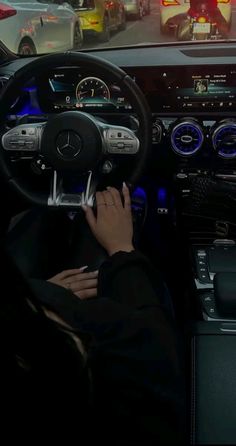 a person is sitting in the driver's seat of a car with their hands on the steering wheel