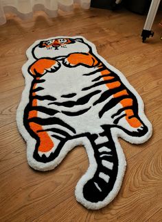 a tiger rug is on the floor with a chair in the back ground behind it