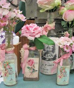 pink flowers are in vases on a table with cards and other items around them