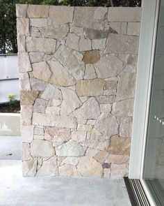 a large stone wall next to a glass door