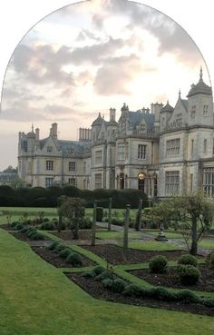 a large building with lots of trees and bushes in front of it on a cloudy day