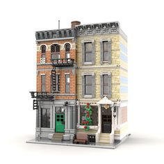 a model of a two story brick building with a green door and window on the second floor