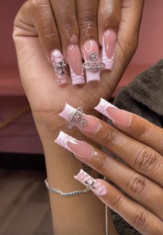 a woman's hands with pink and white nail designs on their nails, holding up her hand