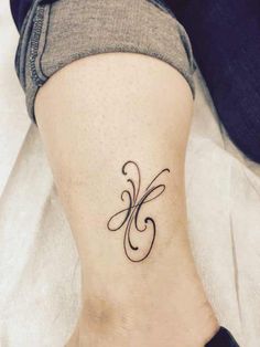 a woman's foot with a small tattoo on the side of her leg,