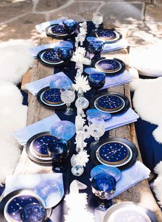 the table is set with blue and white plates, silverware, and napkins