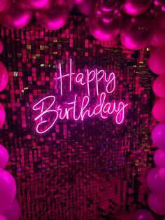 happy birthday neon sign surrounded by pink and purple balloons