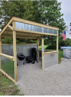 an outdoor bbq with grills and barbecueing equipment in the back ground, next to a large american flag