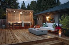 an outdoor deck with seating and lights on it, surrounded by wood planked steps