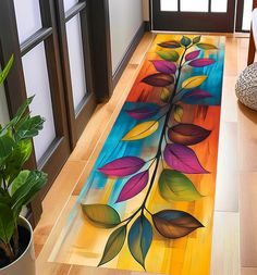 a colorful area rug with leaves painted on the floor next to a potted plant