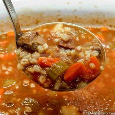 a spoon full of soup with meat and vegetables