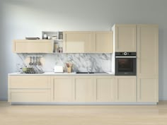 a modern kitchen with marble counter tops and beige cabinetry, along with wooden floors