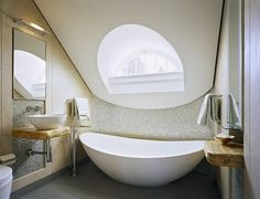 a large white bath tub sitting inside of a bathroom next to a sink and toilet