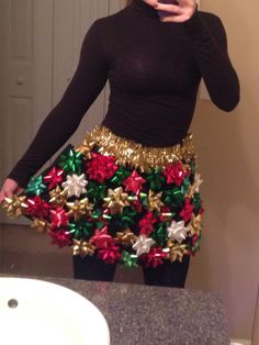 a woman taking a selfie with her cell phone wearing a skirt made out of bows