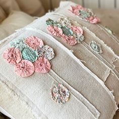 the pillows have flowers on them and are made from old fabric pieces that were used as appliques