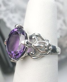 Natural Amethyst Ring Small Fat Oval Design D111 Custom Made to Order Introducing the stunning Amethyst Ring, handcrafted with sterling silver in a Gothic swirl filigree revival design. This custom-made ring features a flawless 3ctw oval natural purple amethyst, measuring 11mm by 9mm in dimension. The inside of the band is stamped with a 925 mark, guaranteeing its quality as sterling silver.  The amethyst on this ring boasts superb color and clarity, making it a truly exquisite piece. The intric Purple Amethyst Ring, Gothic Design, Sterling Silver Filigree, Filigree Ring, Engraved Items, Gothic Jewelry, Silver Filigree, How To Make Notes, Amethyst Ring