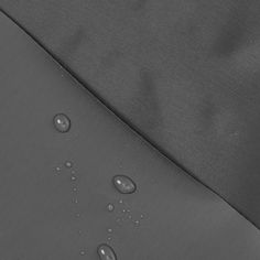 drops of water are seen on the side of an umbrella that has been folded over