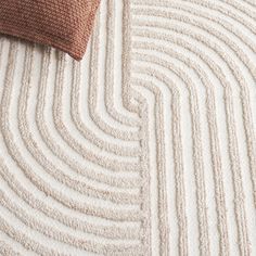 a close up view of a white and brown rug with wavy lines on the floor