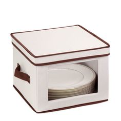 a white box with brown trim holds plates and napkins in the shape of a square