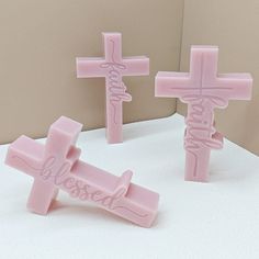 two pink crosses with the word jesus written on them are sitting next to each other