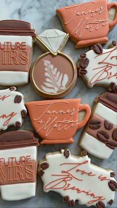 some cookies that are on top of a marble table with coffee cups and saucers