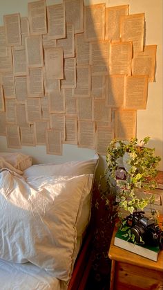 a bed with white sheets and pillows in front of a wall that has books on it