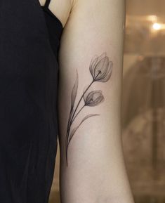 a woman's arm with a flower tattoo on the left side of her arm