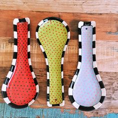 three different shaped spoons sitting on top of a wooden table