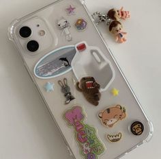 an iphone case with various stickers on it and a cell phone in the background