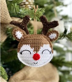 a crocheted reindeer ornament hanging from a christmas tree with pine needles