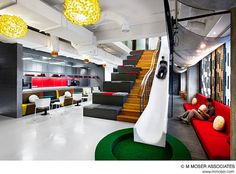 the interior of an office with modern furniture and lighting in white, green, yellow and red colors