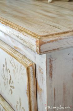 an old dresser is painted white and brown