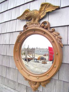 a mirror on the side of a building with an eagle in it's center