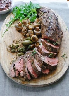 a wooden plate topped with meat and veggies