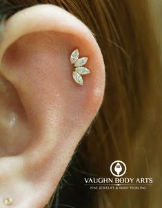 a close up of a person's ear with a small diamond flower on it