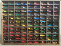 a wooden shelf filled with lots of toy cars