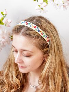 A great way to spread floral cheer! This delightful accessory showcases vibrant multicolored embroidered flowers in red, yellow, green, and blue. Handmade from authentic vintage embroidered ribbon, this headband is designed to bring a burst of color and joy to any outfit. It’s affixed to a soft, luxe base lined with vegan suede for comfort and finished with a soft velvet ribbon for a polished touch. Ideal for adding a playful element to your style, whether you’re heading to a picnic, attending a casual gathering, or simply looking to brighten your everyday look—this headband is sure to stand out. This limited-edition headband features a vintage embroidery. The ends are capped off with a soft white velvet. Handmade in the USA One soft, flexible size Apothecary Candles, Embroidered Ribbon, Precious Gemstones Jewelry, Vintage Ribbon, White Velvet, Turban Headbands, Vintage Embroidery, Curated Gifts, Velvet Ribbon