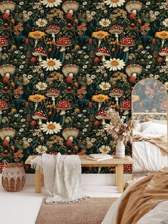 a bed room with a large flower wallpaper and a wooden table in front of it