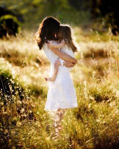 two girls hugging each other in a field