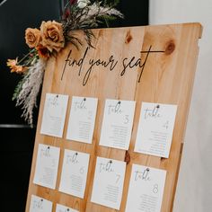 a wooden sign with seating cards attached to it