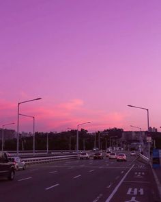 cars are driving down the highway at dusk