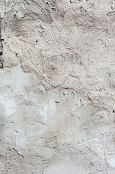 a cement wall with some cracks in the concrete and paint peeling off it's sides